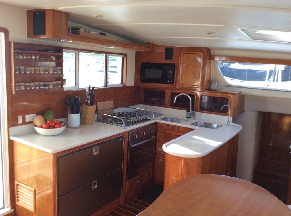 The galley inside Zoom, a 2009 St Francis 50 bluewater catamaran for sale by owner, shows beautiful wood finishes